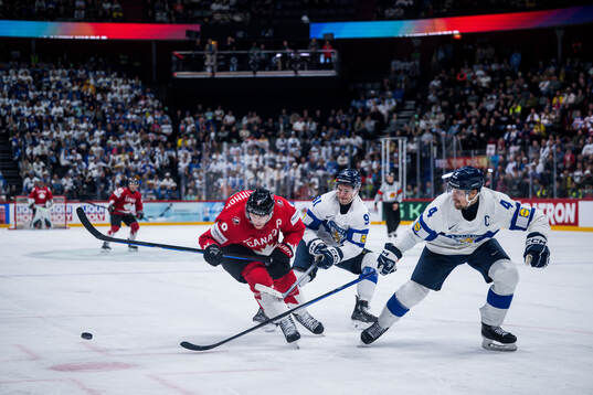 Nathan MacKinnon of Canada and Juho Lammikko and Mikko