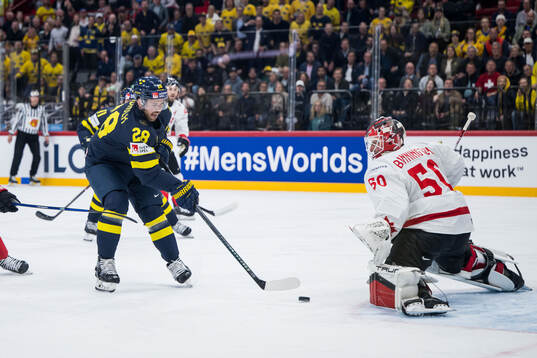 Elias Lindholm of Sweden scores 1-1 behind goaltender