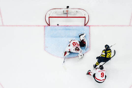Elias Lindholm of Sweden scores 1-1 behind goaltender
