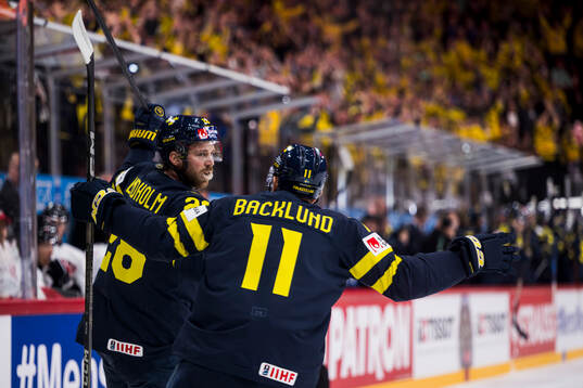 Elias Lindholm and Mikael Backlund of Sweden celebrate the