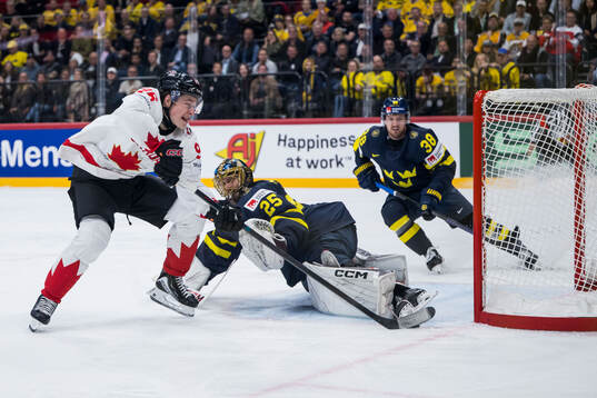 Macklin Celebrini of Canada scores 2-4 behind goaltender