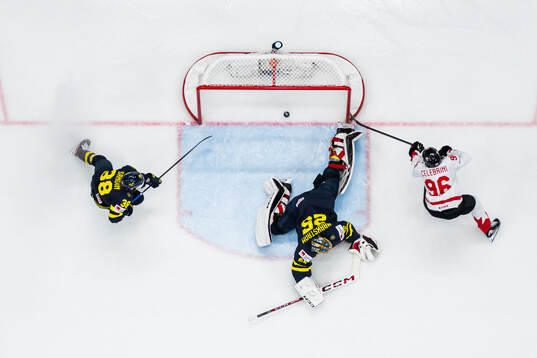 Macklin Celebrini of Canada scores 2-4 behind goaltender