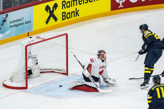 Elias Lindholm of Sweden scores 1-1 behind goaltender