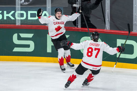 Macklin Celebrini and Sidney Crosby of Canada celebrate