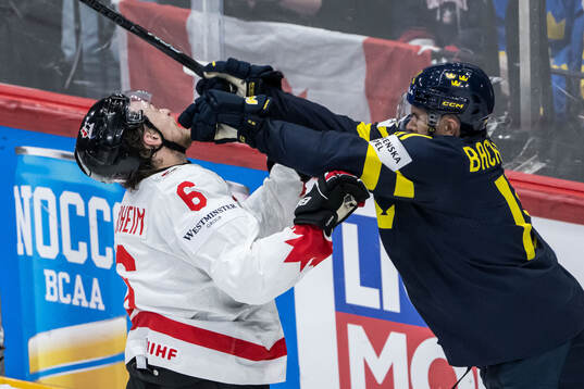 Travis Sanheim of Canada and Mikael Backlund of Sweden