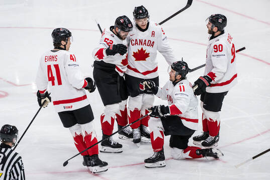 Nathan MacKinnon of Canada celebrates with Ryker Evans,