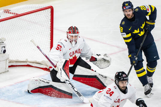 Goaltender Jordan Binnington of Canada and Elias Lindholm
