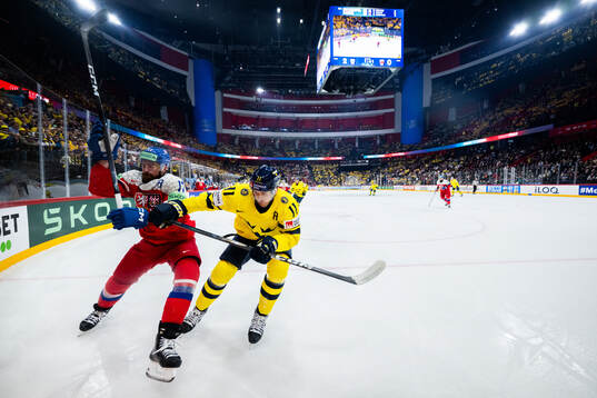 Filip Hronek of Czech Republic and Mikael Backlund of Sweden