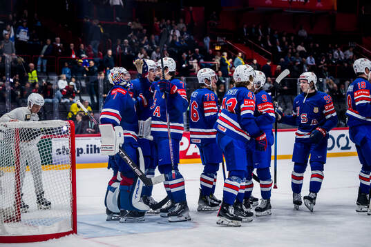 Goalkeeper Jeremy Swayman celebrates with team mates