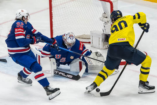 Logan Cooley and goaltender Jeremy Swayman of USA against