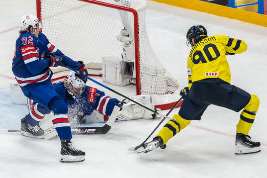 Logan Cooley and goaltender Jeremy Swayman of USA against