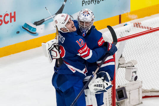Shane Pinto and goaltender Jeremy Swayman of USA celebrate