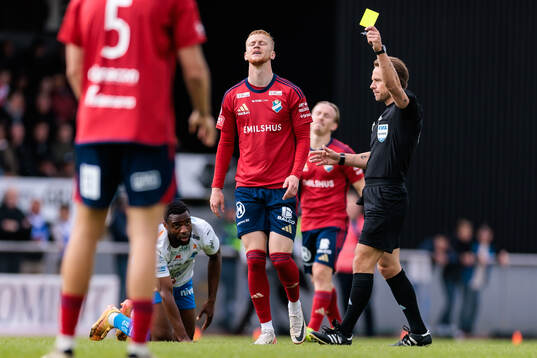 Domare Kristoffer Karlsson delar ut ett gult kort till