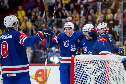 Shane Pinto of USA celebrates with Zach Werenski and