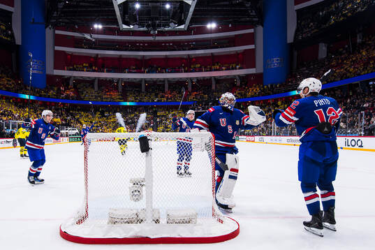 Goaltender Jeremy Swayman and Shane Pinto of USA celebrate