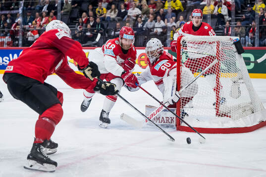 Nicholas B Jensen and goaltender Frederik Dichow of Denmark
