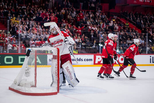 Goaltender Frederik Dichow of Denmark looks dejected