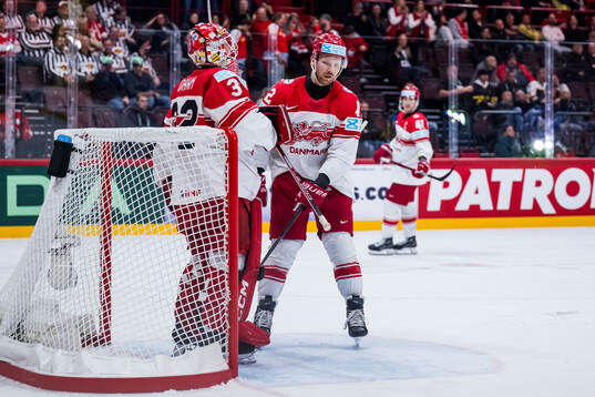 Goaltender Sebastian Dahm and Phillip Bruggisser of Denmark