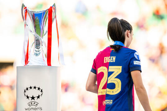 Ingrid Syrstad Engen of Barcelona walks past the trophy