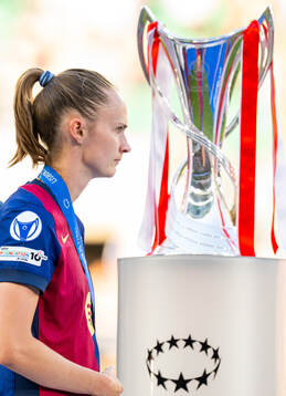Caroline Graham Hansen of Barcelona walks past the trophy
