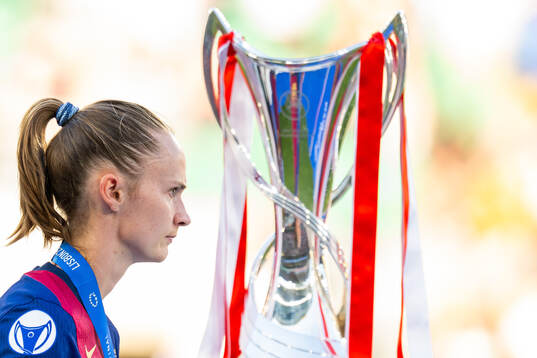 Caroline Graham Hansen of Barcelona walks past the trophy