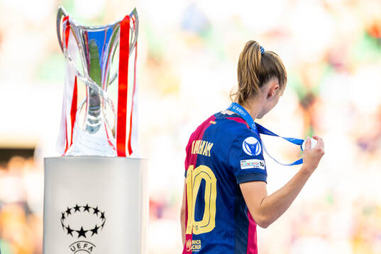 Caroline Graham Hansen of Barcelona walks past the trophy