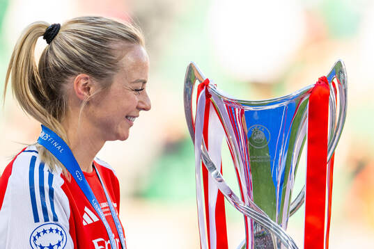 Amanda Ilestedt of Arsenal looks at the trophy