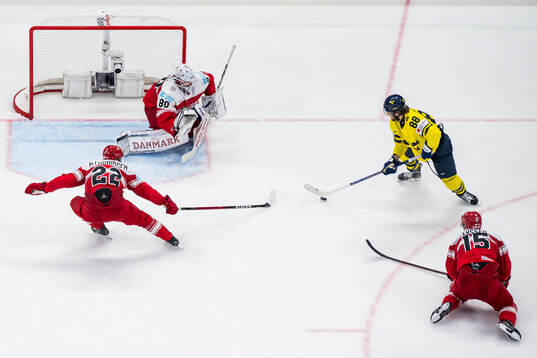 Markus Lauridsen and goaltender Frederik Dichow of Denmark