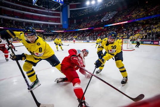 Nick Olesen of Denmark competes for the puck with Jonas