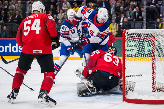 Drew O'Connor of USA and goaltender Leonardo Genoni of