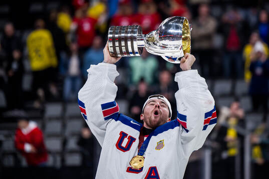 Goaltender Jeremy Swayman of USA celebrates with t he trophy