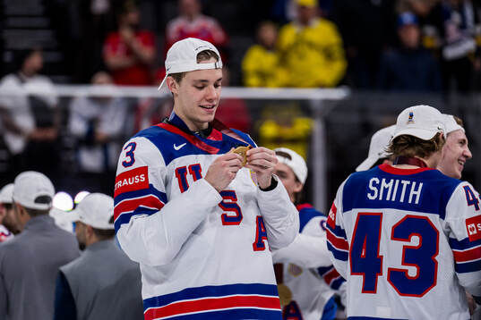 Alex Vlasic celebrates with his gold medal