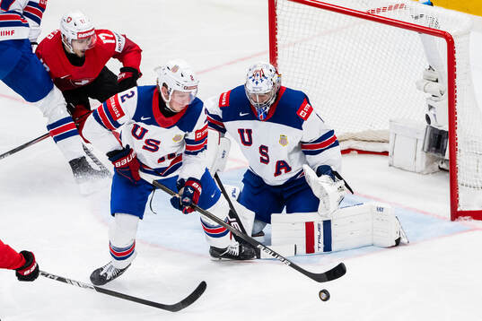 Jackson LaCombe and goaltender Jeremy Swayman of USA