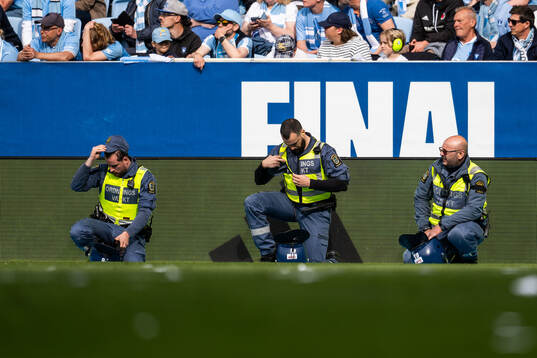 Ordningsvakter positionerar sig längs sidlinjen