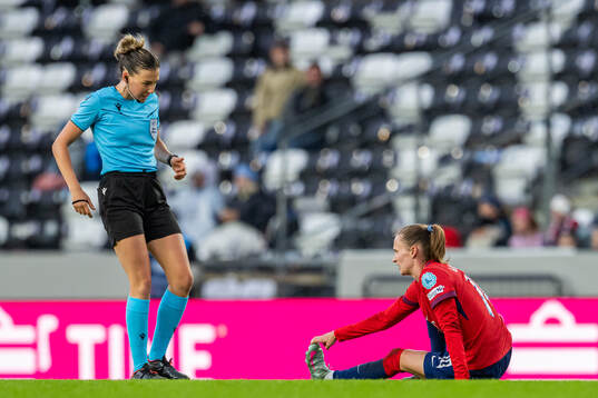 Referee Olatz Rivera Olmedo and Caroline Graham Hansen of