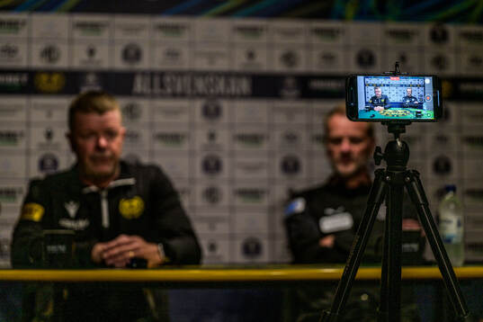 En presskonferens live sänds via en telefon