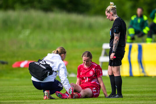 Andrea Thierry of Denmark receives medical attention by