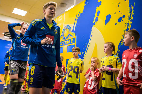 Lina Hurtig of Sweden walk by mascots in the player tunnel