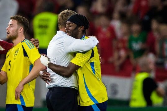 Head coach Jon Dahl Tomasson hugs Anthony Elanga of Sweden