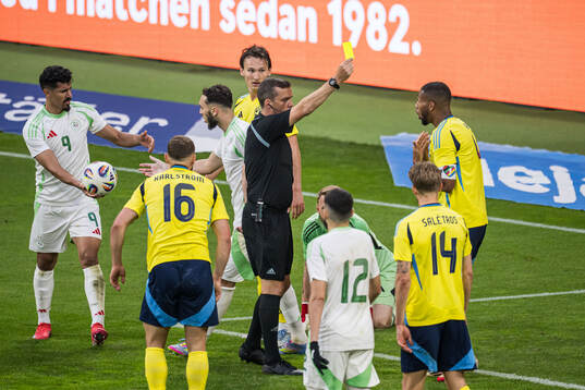 Referee Robert Harvey and Isak Hien of Sweden