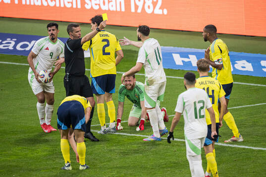 Referee Robert Harvey and Isak Hien of Sweden