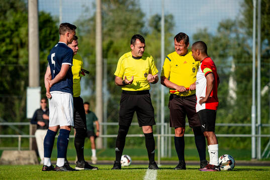 Domare Elvid Imsirovic med FC Näsets Lucas Lundström och