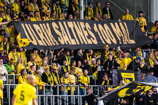 Spectators in the stands with a banner