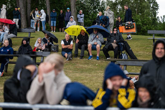 Spectators with umbrellas