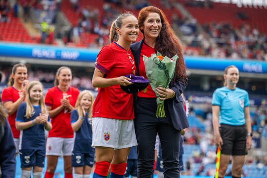 Guro Reiten receives a cap for playing 100 games for Norway