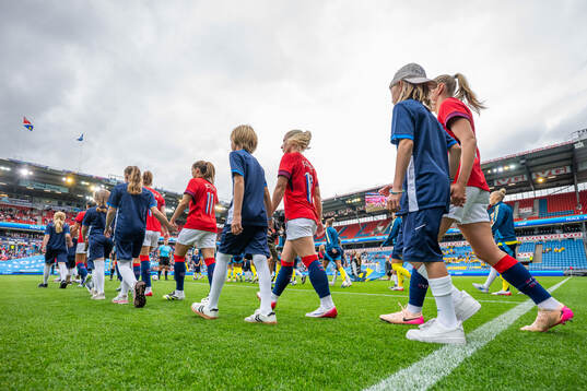 Thea Bjelde and players of Norway enter the pitch