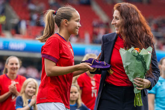 Guro Reiten receives a cap for playing 100 games for Norway
