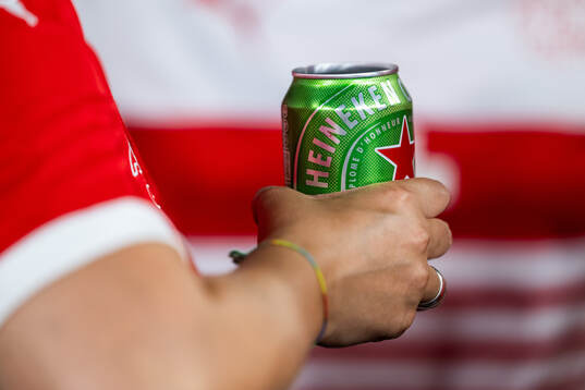 A spectator holds a beer can