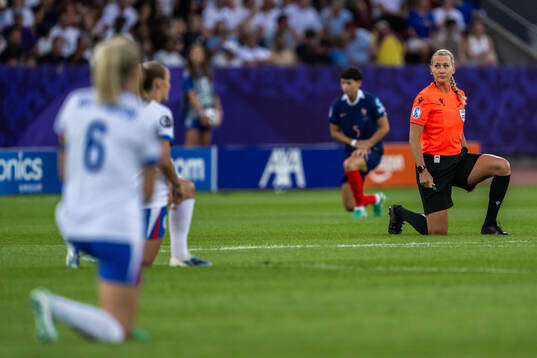 Referee Tess Olofsson takes a knee