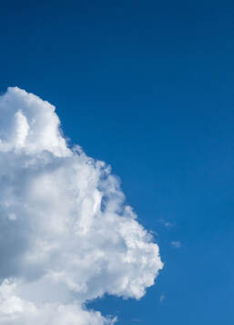 A cloud and a blue sky is seen